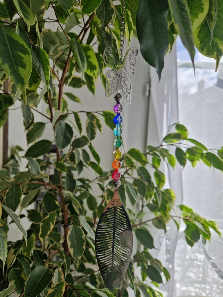 Attrape-lumière inox et verre véritable, accroché près d'une source de lumière dans un ficus pour un rendu tout en légèreté.